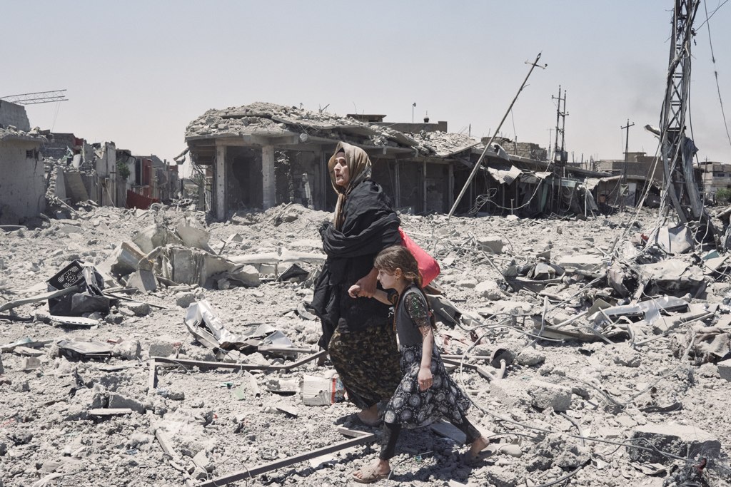 Mosul, Iraq. Giugno 2017 - Una donna e una bambina fuggono verso una zona più sicura nel quartiere al-Zanjili, dopo essere scappate da un’area controllata dall’ISIS.